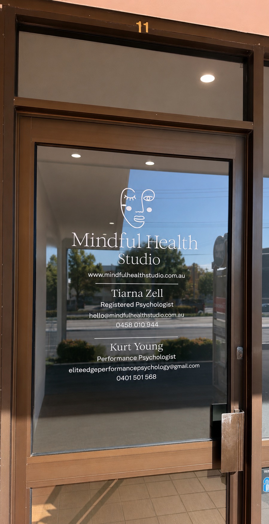 Entrance to Mindful Health Studio at Suite 11, showing the studio signage with practitioner details on the glass door
